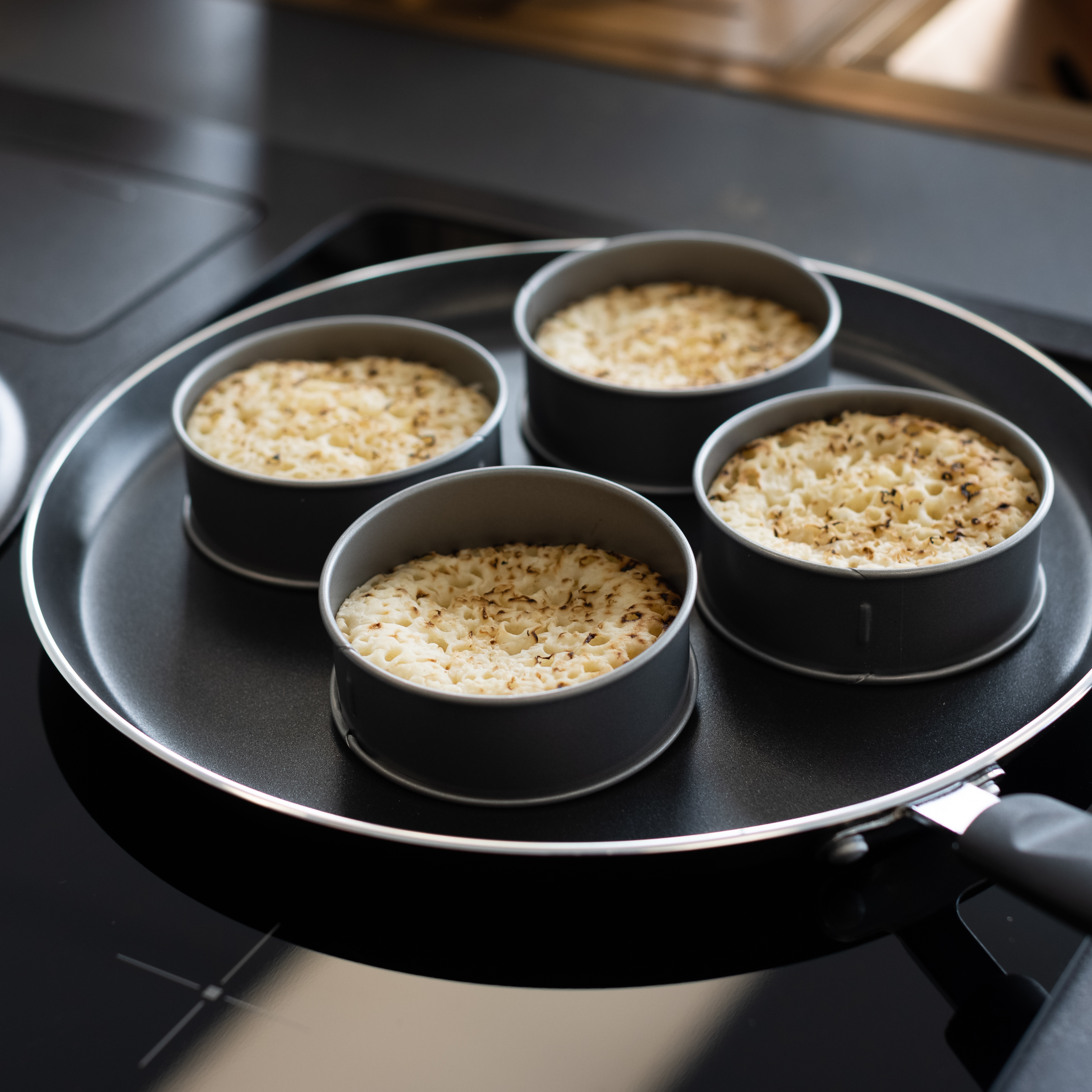 freshly made homemade crumpets on a frying pan 